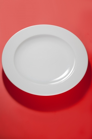 white empty plate ping -red background with shadow の写真素材