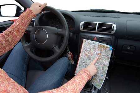 woman drive a car and show by finger point at map