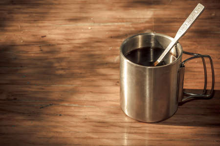 Steel cup on a wooden tableの写真素材