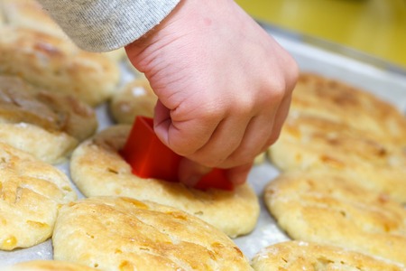Childrens hands pressing the dough with cutter to make cute gingerbread . small workshop indoors.