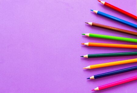 Collection of colored pencils on a purple background top view and copy space. Education, Back to...