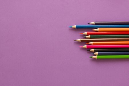 Collection of colored pencils on a purple background top view and copy space. Education, Back to...
