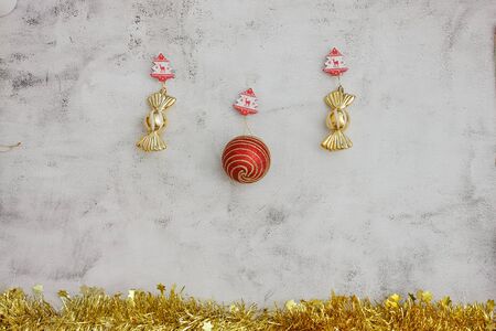 Christmas grey background with golden candy and big red baubles. golden tinsel bottom. Space for textの写真素材