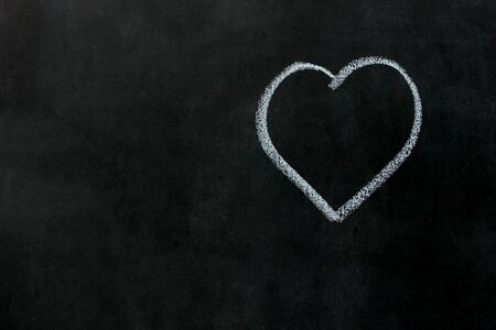 White heart drawing chalk on black chalkboard. Concept Valentines dayの写真素材