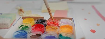 Brush dips in colored paint gouache in a box. Concept home education.の写真素材