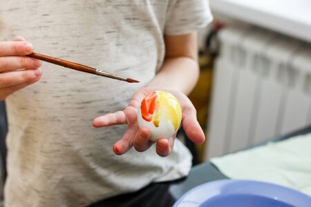 preparation for Easter. Glasses with colored paint and white eggs with a blue plateの写真素材