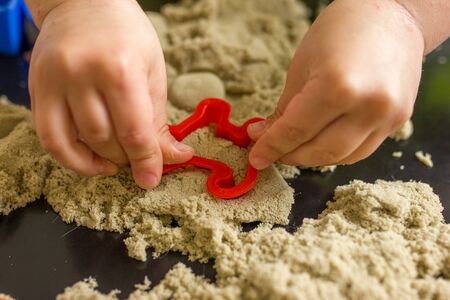 Cute little boy age of 3 years plays kinetic sand at homeの写真素材