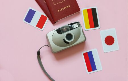 Travel concept overhead stop motion, camera, passport, flags of country on pink backgroundの写真素材