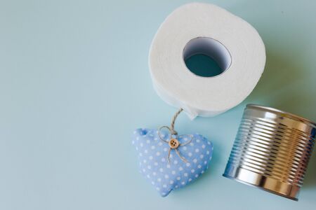 Donation food and charity concept. Pack of rice, toilet paper and canned food on blue backgroundの写真素材