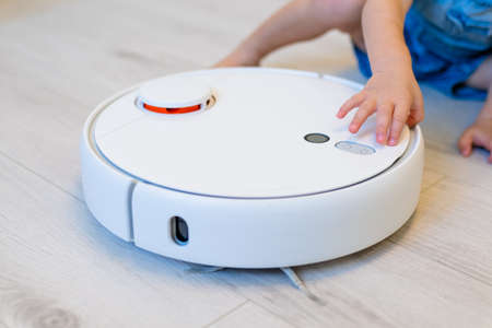 little boy 2 years ago starts a robot vacuum cleanerの写真素材