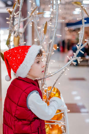 Cute little school kid boy on Christmas market. Holidays, christmas, childhood and people concept.の写真素材
