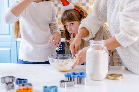 mother and children preparation holiday food. daughters bake cookies for Christmasの写真素材
