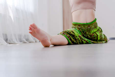 Cropped Young woman doing leg split stretch yoga pose