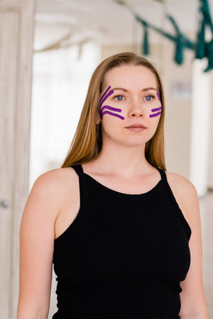 woman 30 -40 years old applying lifting tape . concept of facial rejuvenation, Kinesiotaping for face.の写真素材