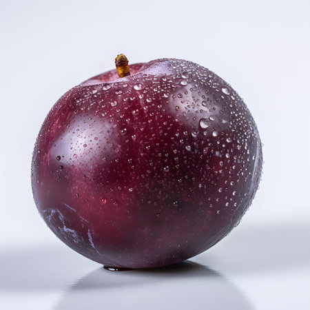 Plum with water drops on a white background, close-upの素材