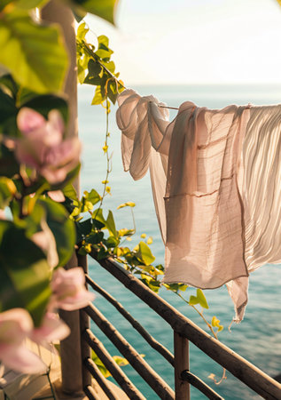 Wedding dress hanging on the balcony over the sea at sunsetの素材