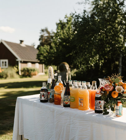 Wedding table with bottles of orange juice in the garden.の素材
