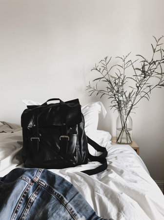 black leather backpack with jeans on the bed in the bedroom, travel conceptの素材