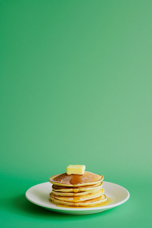 Stack of pancakes with honey and lemon on a green background, copy spaceの素材