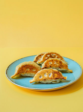 Fried dumplings on a blue plate on a yellow backgroundの素材