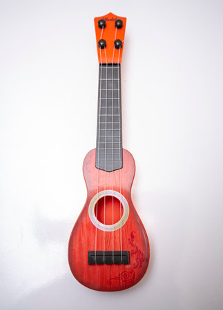 Ukulele on a white background. A red ukulele.