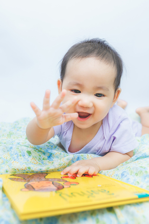 baby laughing with bookの写真素材