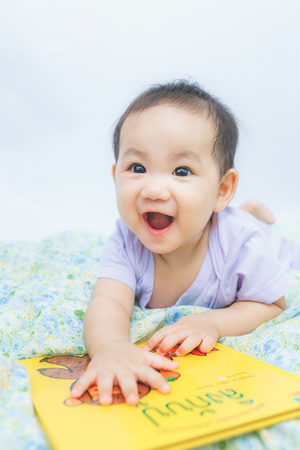 baby laughing with bookの写真素材