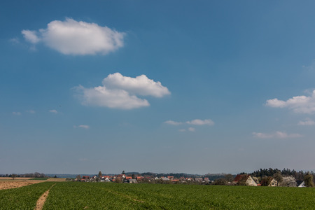 Little village in the middle of the german countryside with hills, forests, fields and meadowsの写真素材