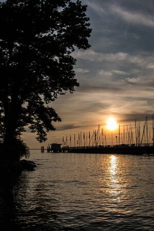 Golden sunset above the lake or the sea near the landing pier
