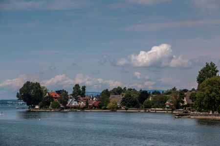 Little spit of land into the water and a little villageの写真素材
