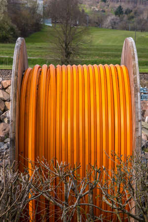 Big orange cable reel outside on the groundの写真素材
