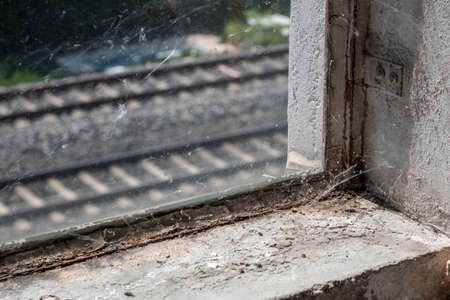 Old and dusty window with spiderwebs dirt