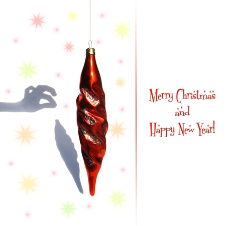 Christmas card with a joke  Christmas red toy and funny unreal shadowの写真素材