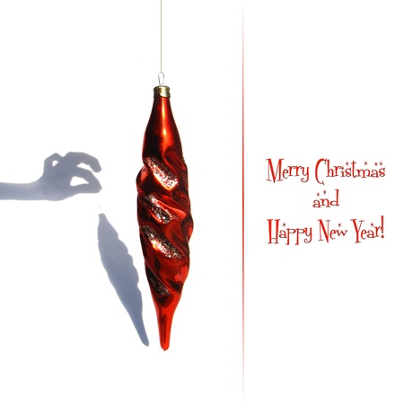 Christmas card with a joke  Christmas red toy and funny unreal shadowの写真素材