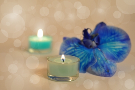 Candles burning, shells and blue orchid on a light blurred backgroundの写真素材
