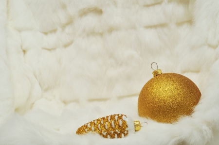 Christmas background - gold Ball and cone on white fur with space for textの写真素材