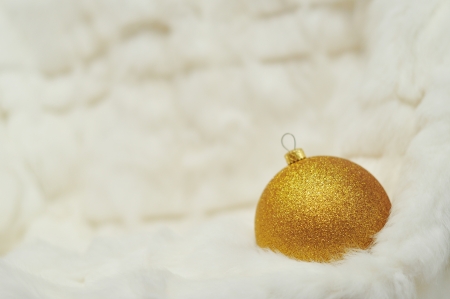 Christmas background - golden Ball on white fur with space for textの写真素材