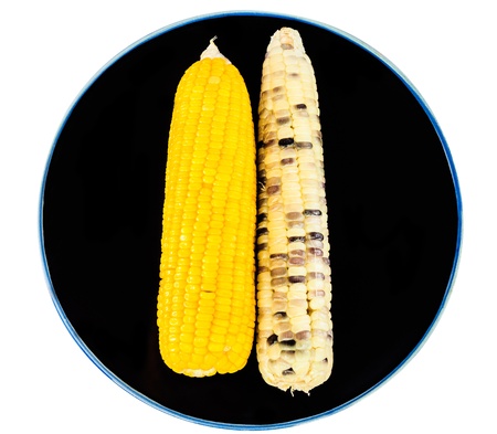 Two type of boiled corns on black plateの写真素材
