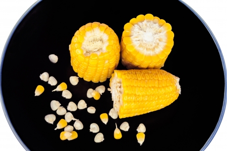 The divided boiled corn on black plateの写真素材
