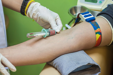 Nurse collecting a blood sample from a patient 