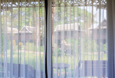 Green rice field in the villa built from rice barn see trough white curtainの写真素材