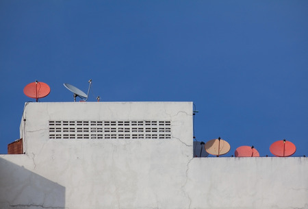 Many satelite dish on the roof top of building in Thailandの写真素材