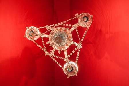 Crystal chandelier hang on red ceiling look from uprisen angleの写真素材