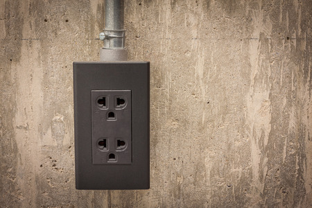 Electric plug on grunge cement wall background