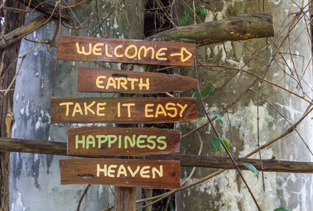Wooden sign on old wooden pillar with vine