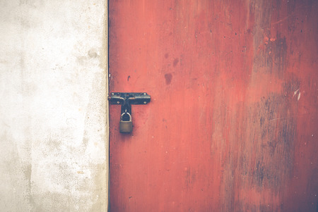 Old red door and white wall with texture and scratchの写真素材