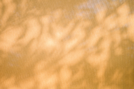 Abstract background from lights and shadow on yellow fabric
