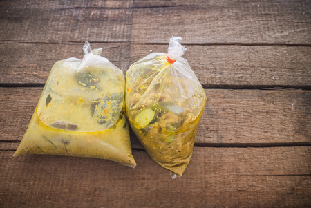 Thai curry in plastic bag on brown wooden backgroundの写真素材