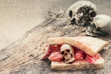 Meat sandwich with tiny skulls on wooden log ,halloween conceptの写真素材