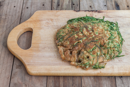 Omelet with vegetables,Climbing Wattle,Thai food on wooden chopping blockの写真素材